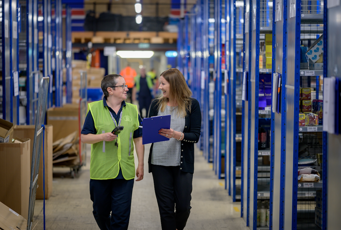 Women walking through warehouse aisle
